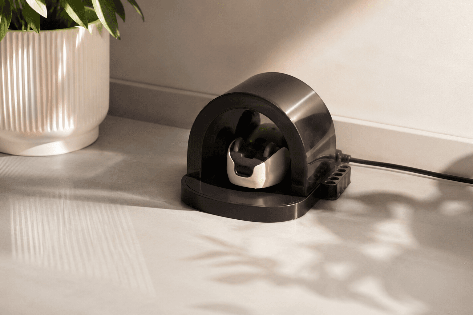 Mousr resting in its mouse-hole inspired charging dock